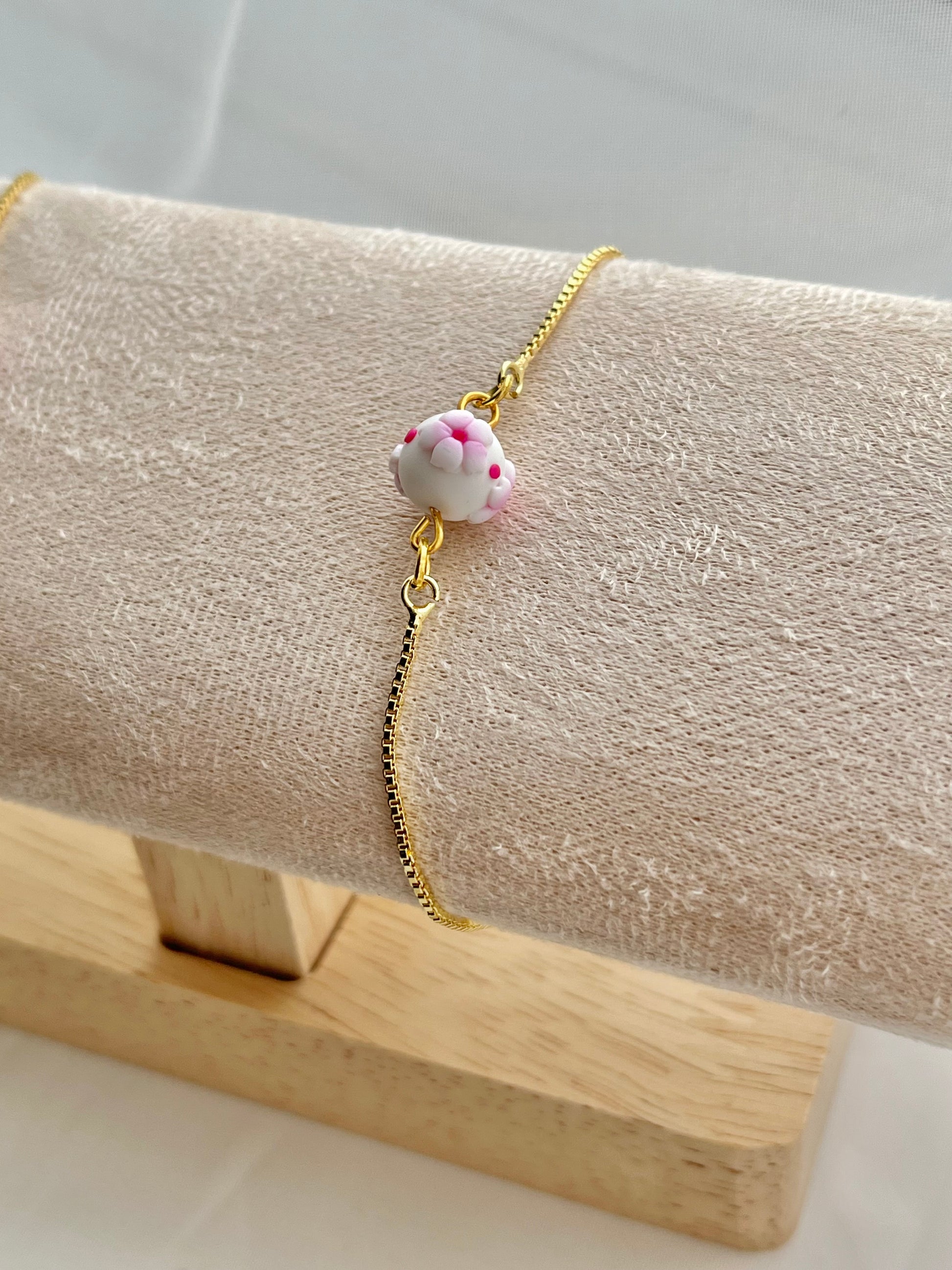 One floral bracelet in cherry blossom style with 1 bead on a bracelet stand