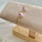 One floral bracelet in cherry blossom style with 2 beads on a bracelet stand