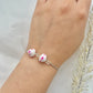 A floral bracelet with a rhodium plated chain in cherry blossom style with 2 beads on a hand
