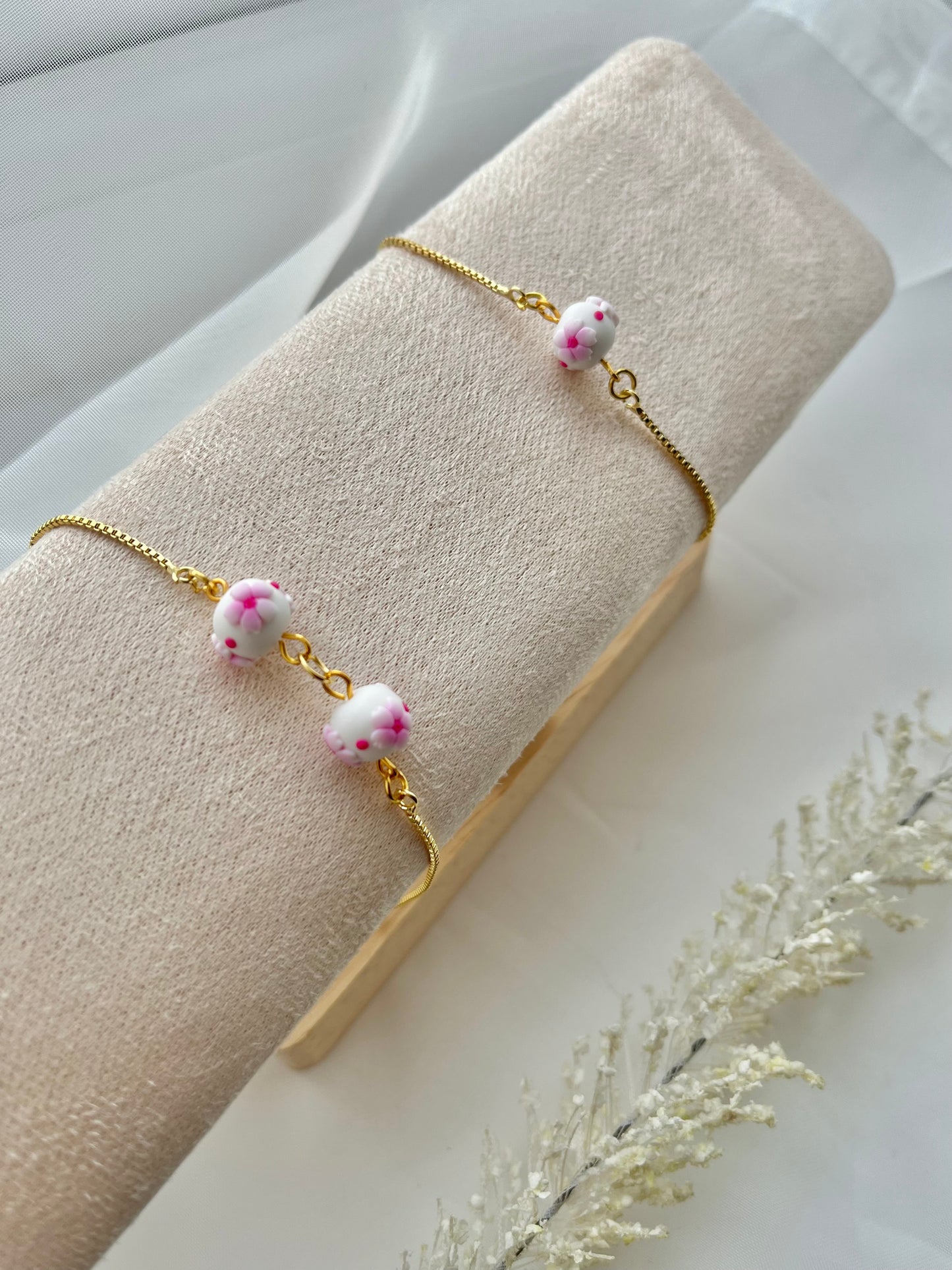 Two floral bracelet in cherry blossom style on a bracelet stand