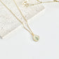 Gold clay necklace with a daisy pendant on a light surface