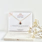 Gold clay necklace on a July Studio jewellery card card with a white background and dried flowers.