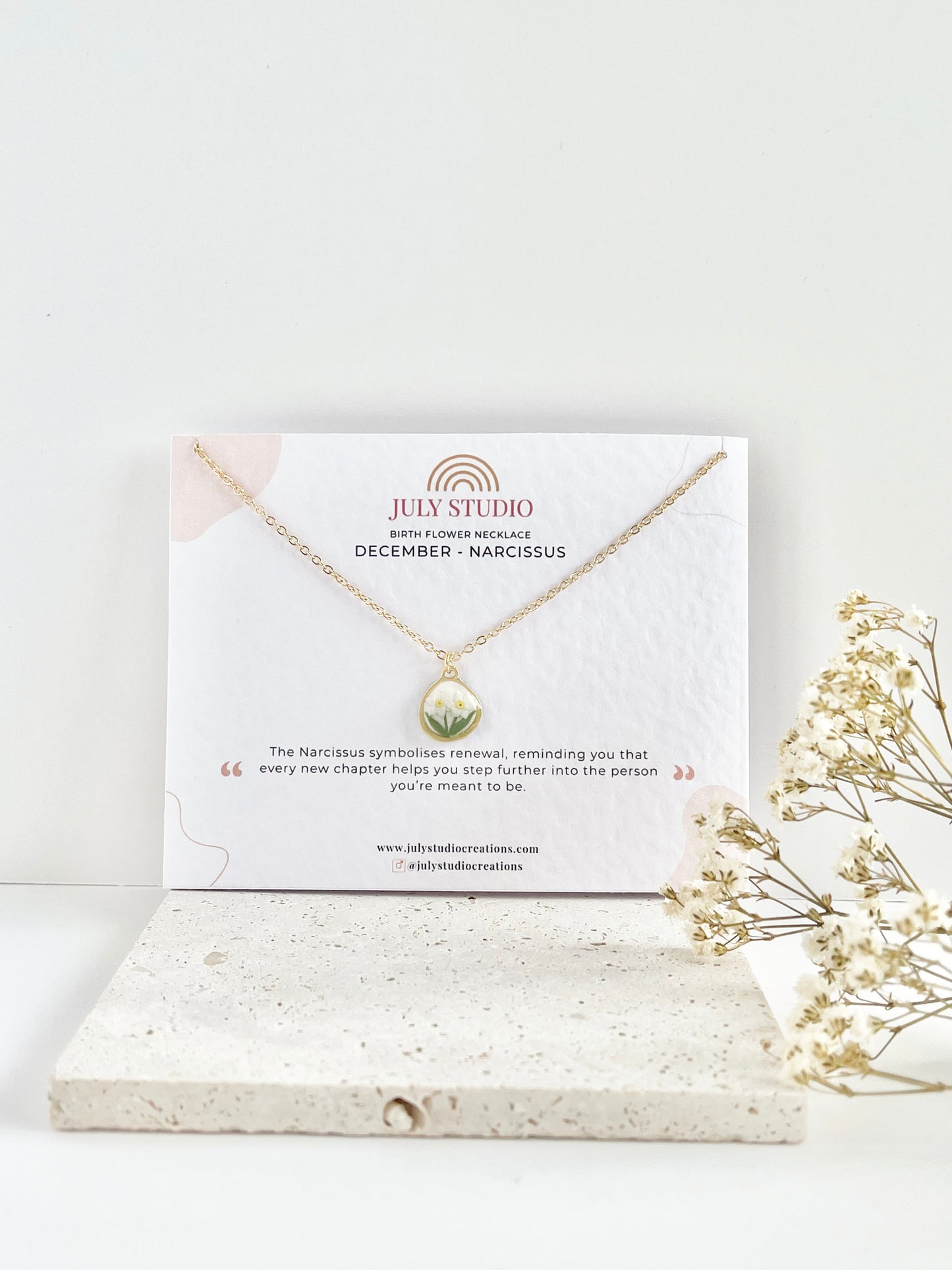 Gold clay necklace on a jewellery card with 'July Studio' branding, featuring dried flowers on a light background.