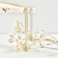 Dainty necklaces in gold and silver with a teardrop pendant with daises featuring dried flowers on a white background.