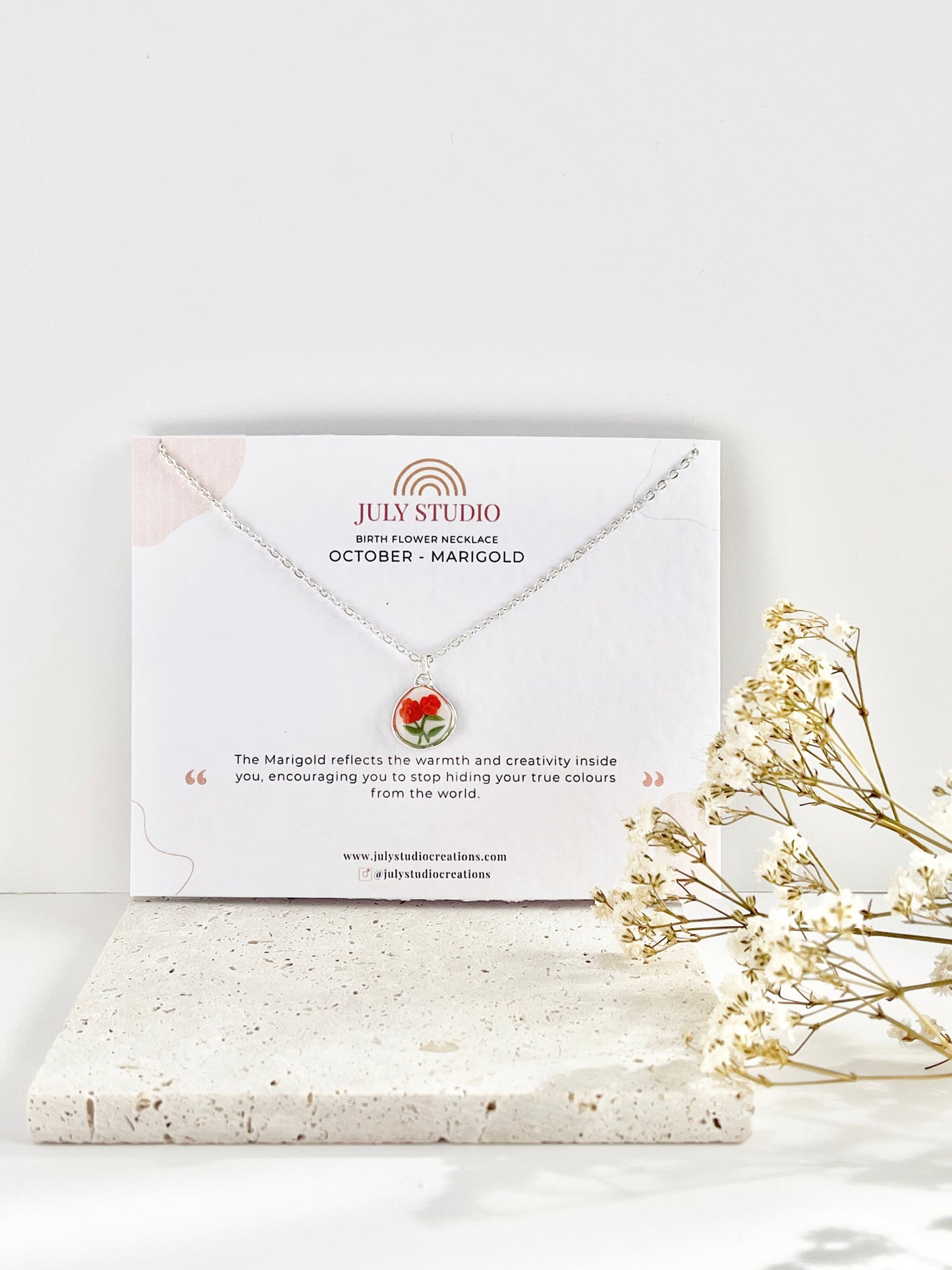 Silver clay necklace with a floral pendant on a July Studio jewellery card with a white background