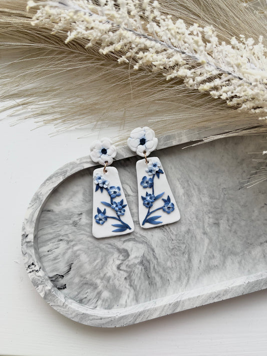 Long blue and white floral blue china clay earrings on a grey trinket dish